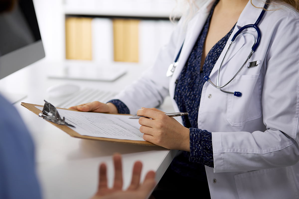 Health care provider writing on clipboard